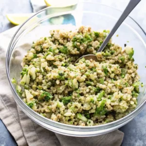 Lemon Quinoa Salad with Fresh Herbs – A glass bowl filled with fluffy quinoa mixed with chopped green herbs and a light lemon dressing.