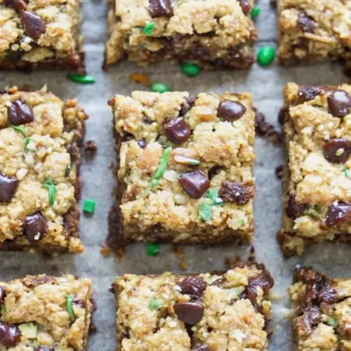 Chocolate chip zucchini oat bars cut into squares on a baking sheet